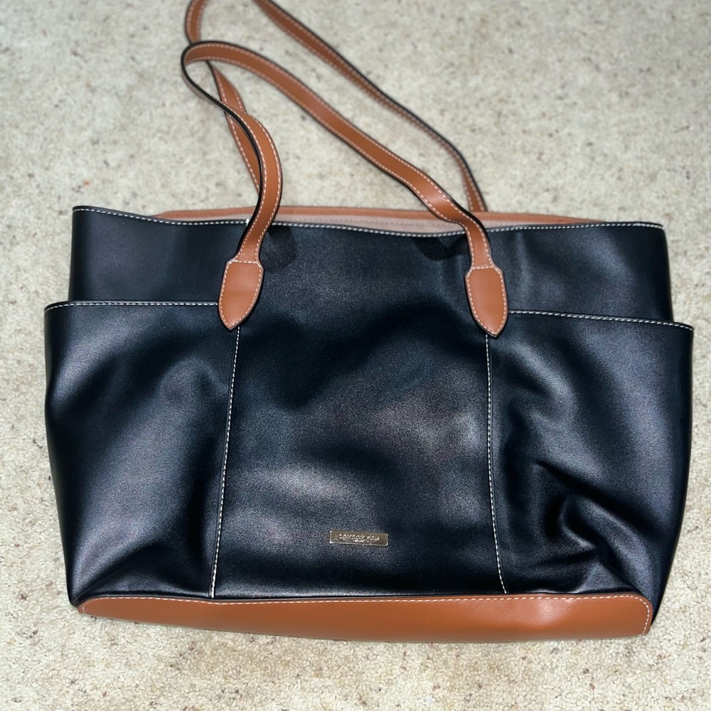 Black leather London Fog tote with brown trim and two large outer pockets.